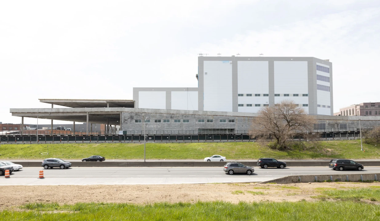 Terminal Logistics Center with tiered architecture viewed from highway edge on sunny day