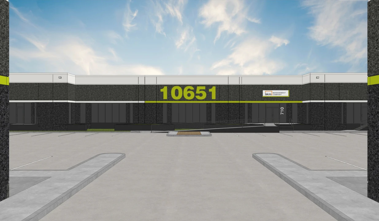 Modern industrial building facade with large parking lot and prominent 10651 address number